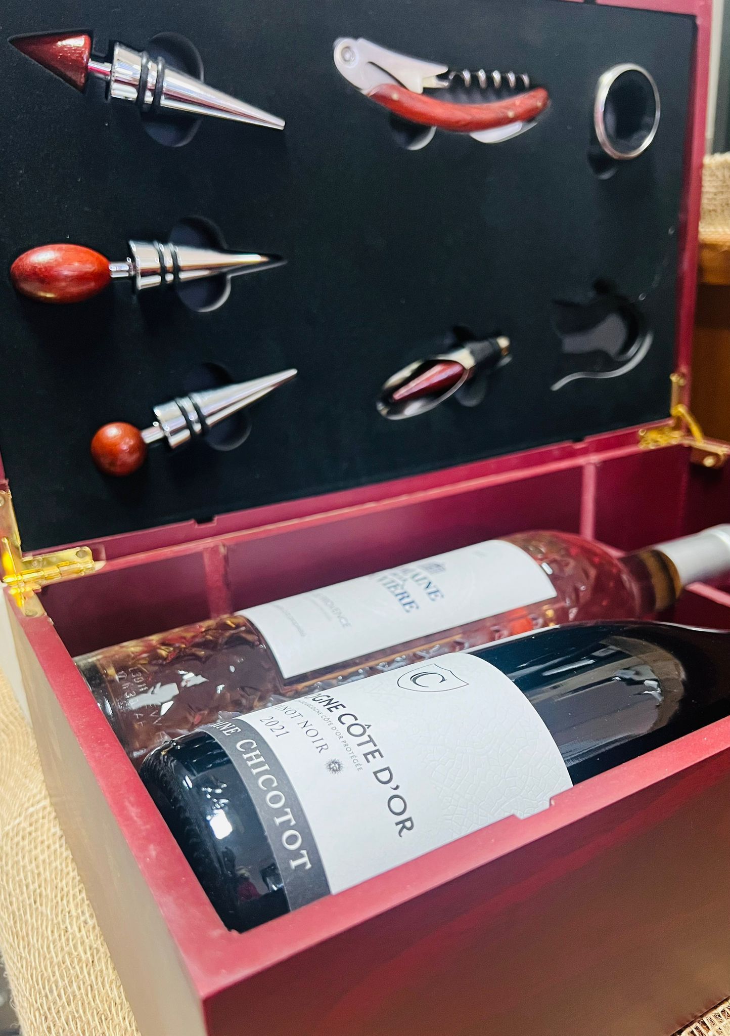 Una confezione regalo in legno per il vino contiene due bottiglie e un set di accessori in acciaio inossidabile, inclusi i tappi.