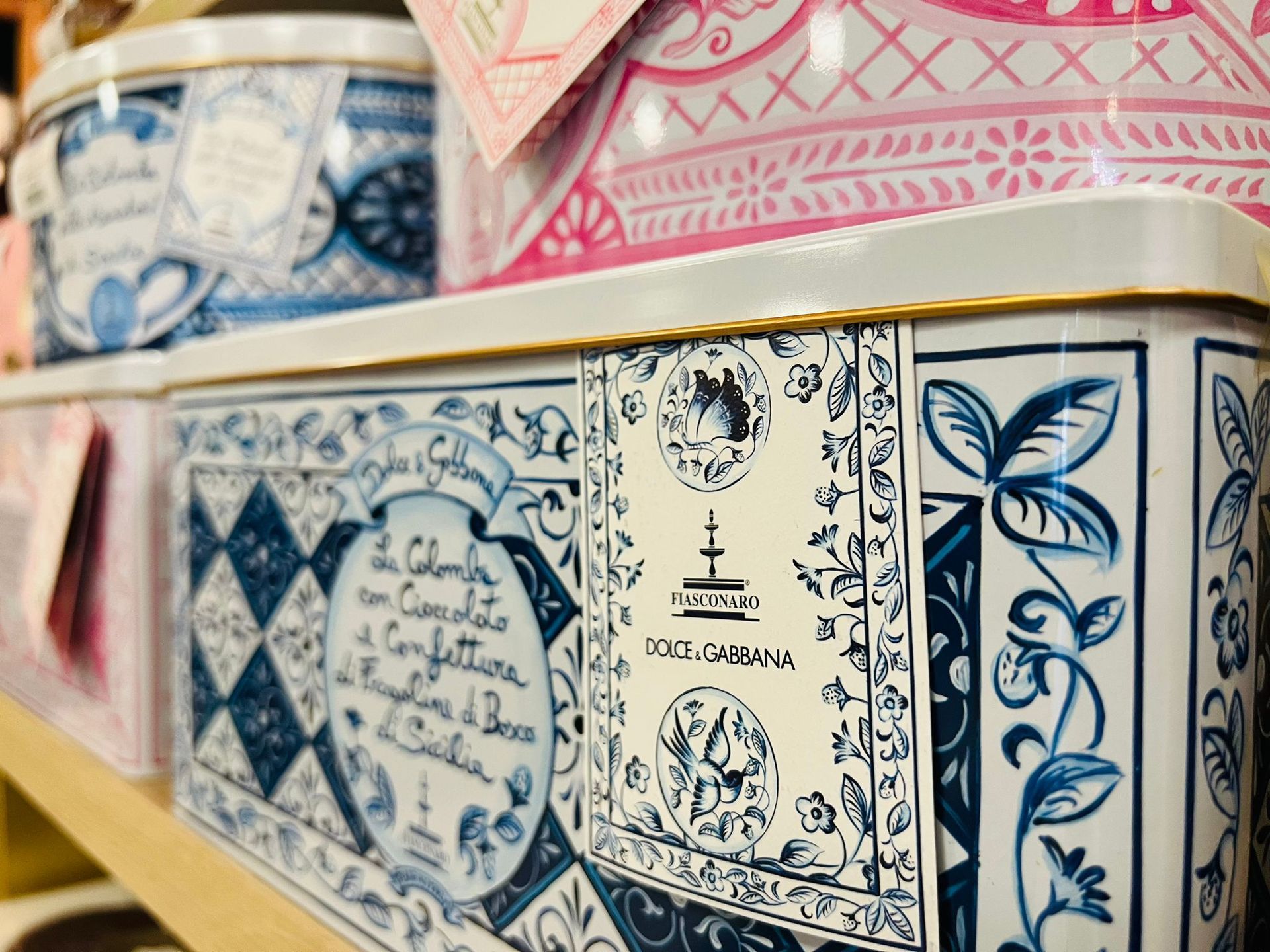 Scatola decorativa rettangolare di Dolce & Gabbana con motivo blu e bianco, esposta su uno scaffale di un negozio.