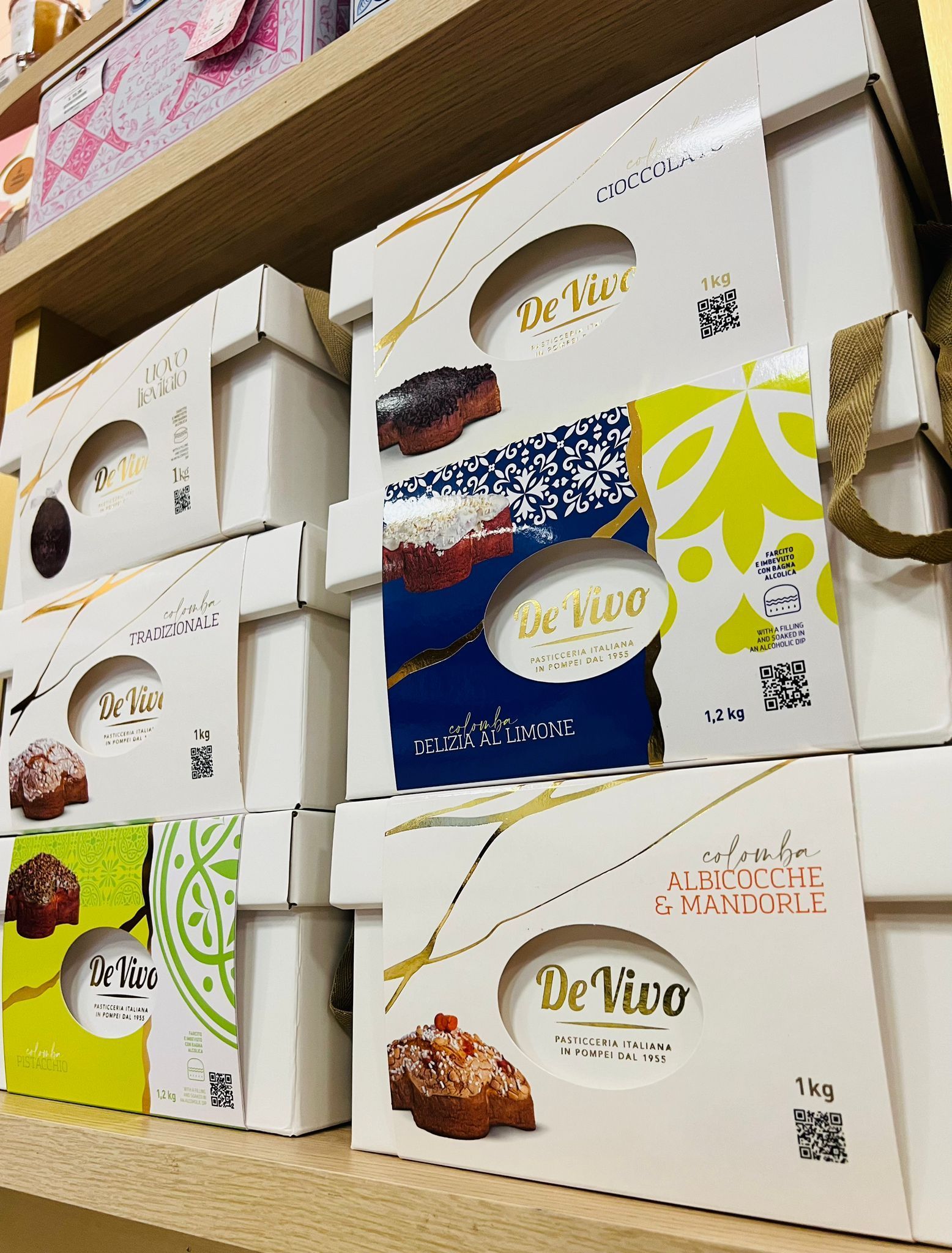 Uno scaffale espositivo con pasticcini in scatole bianche a marchio