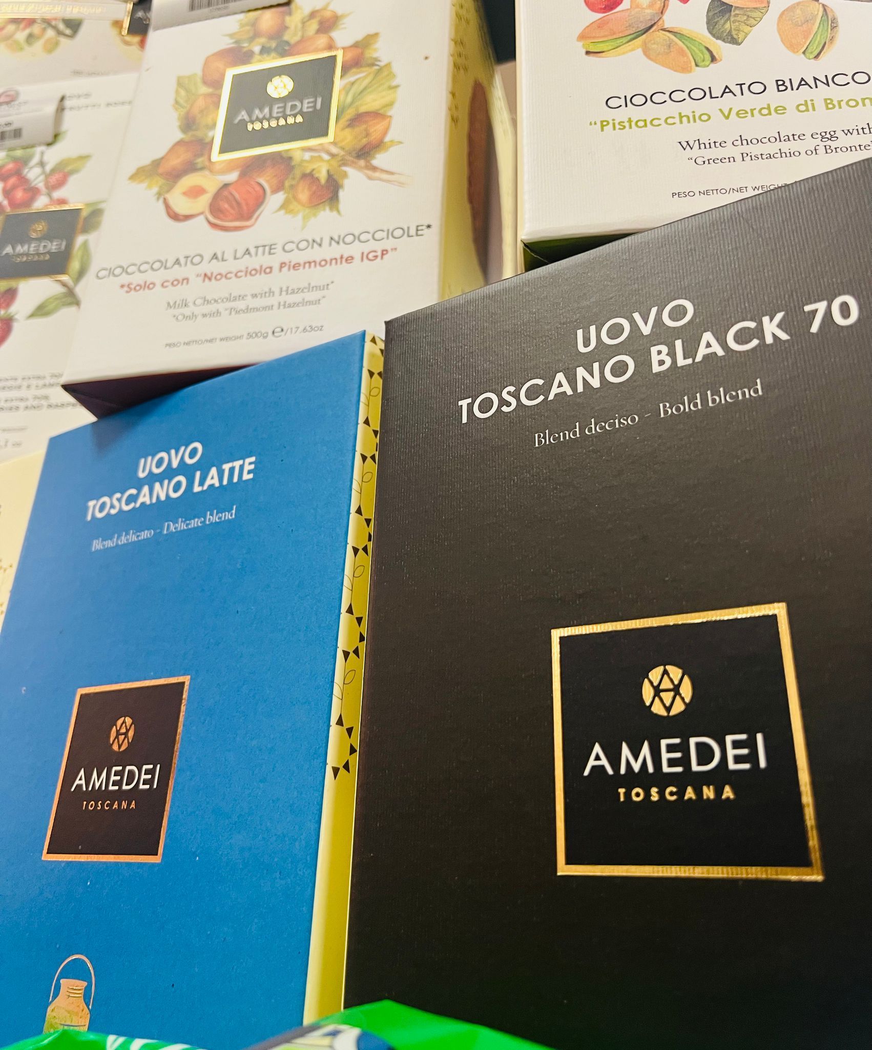 Una vetrina con le confezioni di uova di cioccolato Amedei Toscana, disponibili nei colori nero, blu e bianco decorato.