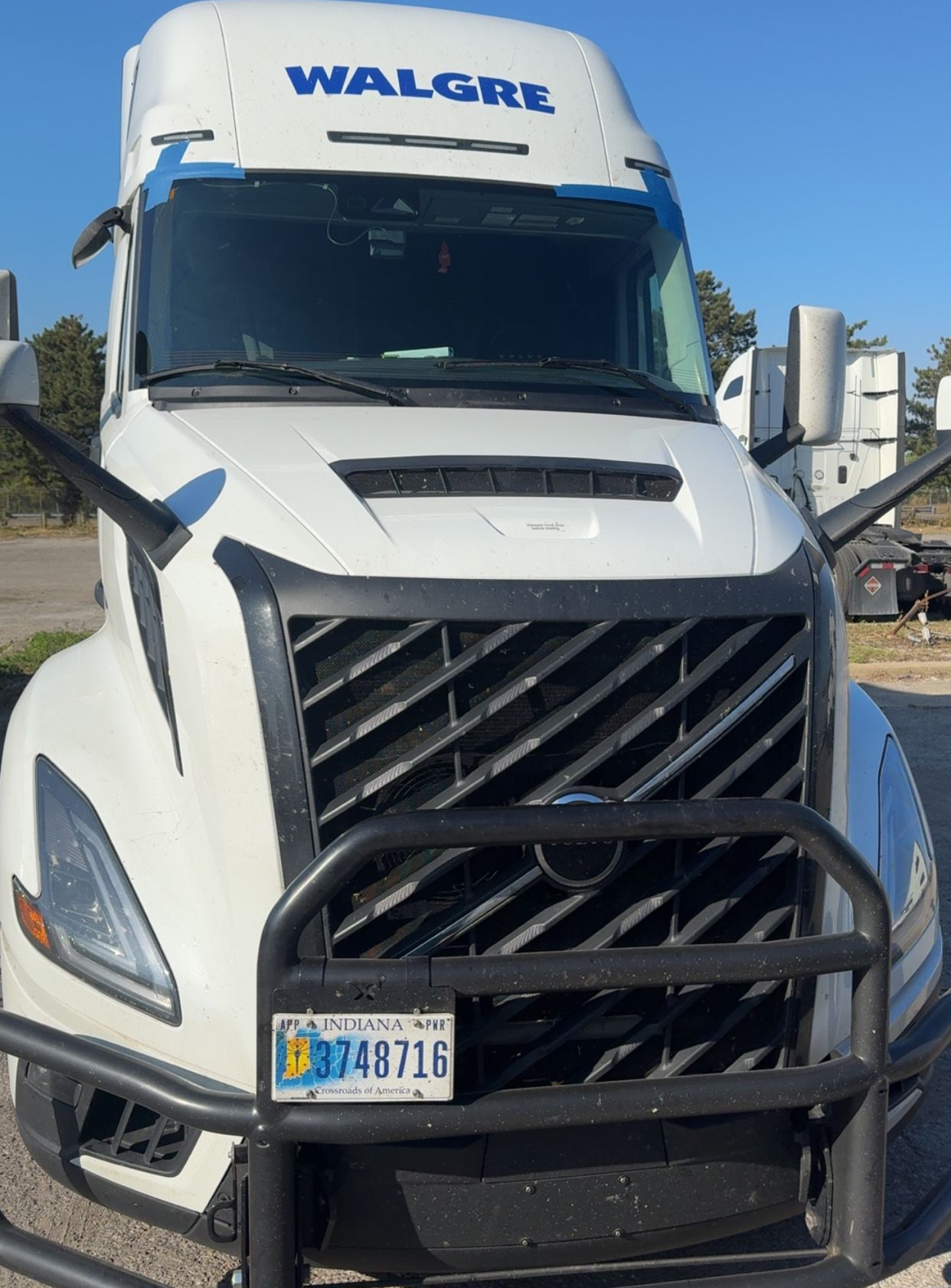 White Walgre semi-truck with a black bull bar parked outdoors, front view.