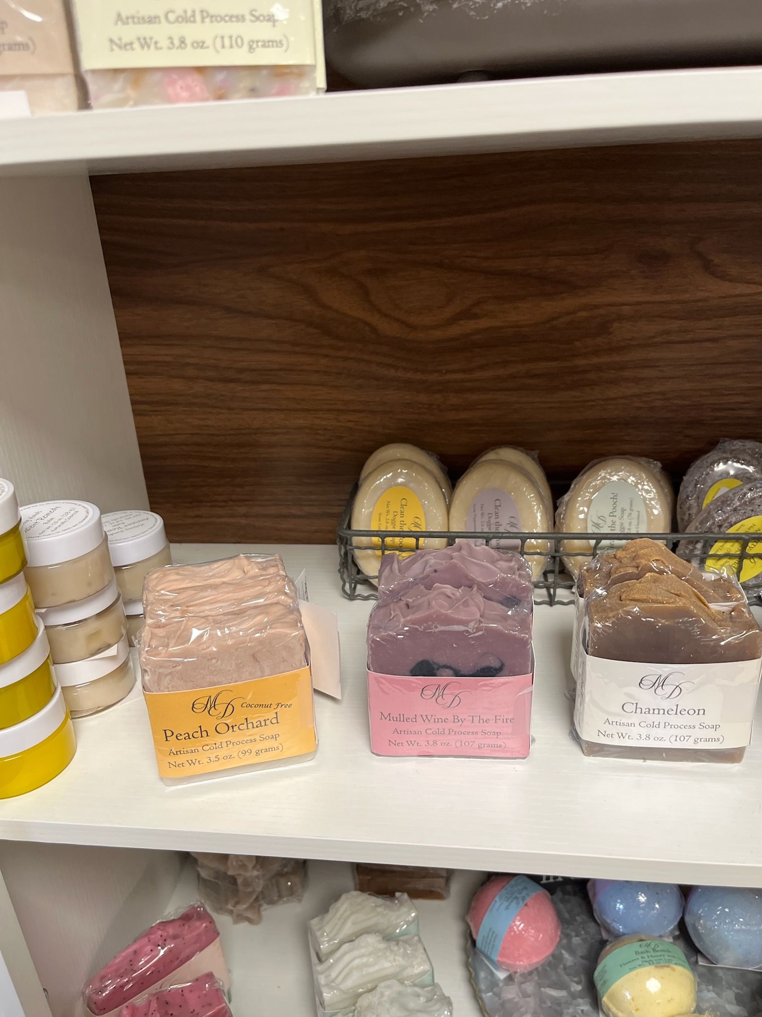 Shelf of colorful packaged soaps and bath bombs in a store display