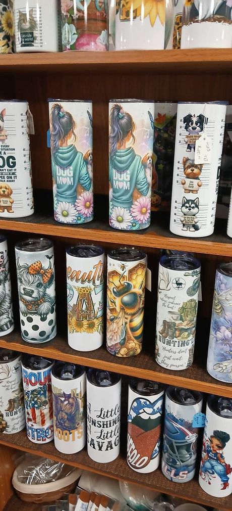 Shelf of colorful decorative tumblers with assorted illustrated designs in a shop display