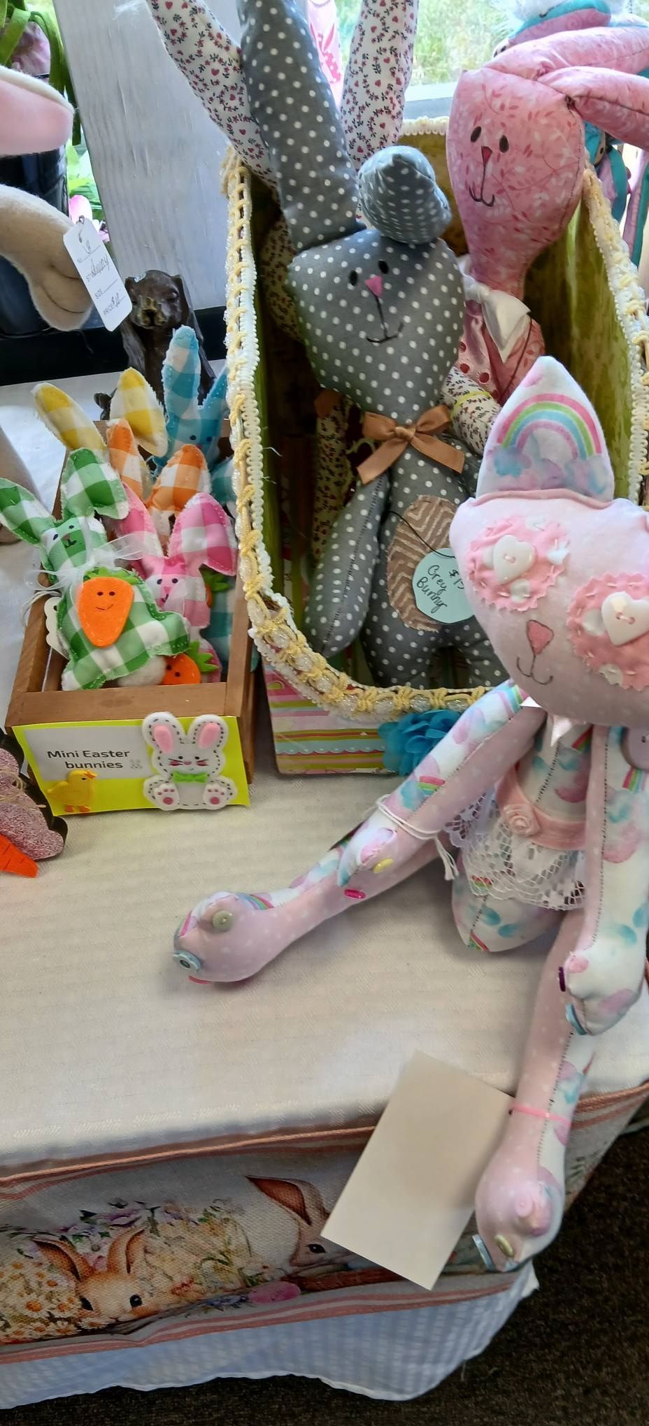 Pastel stuffed bunnies and floral baskets arranged on a shelf in a shop display