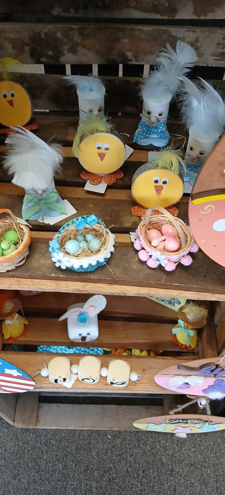 Decorated pastry display with chick, bunny, and fish figurines on a wooden shelf