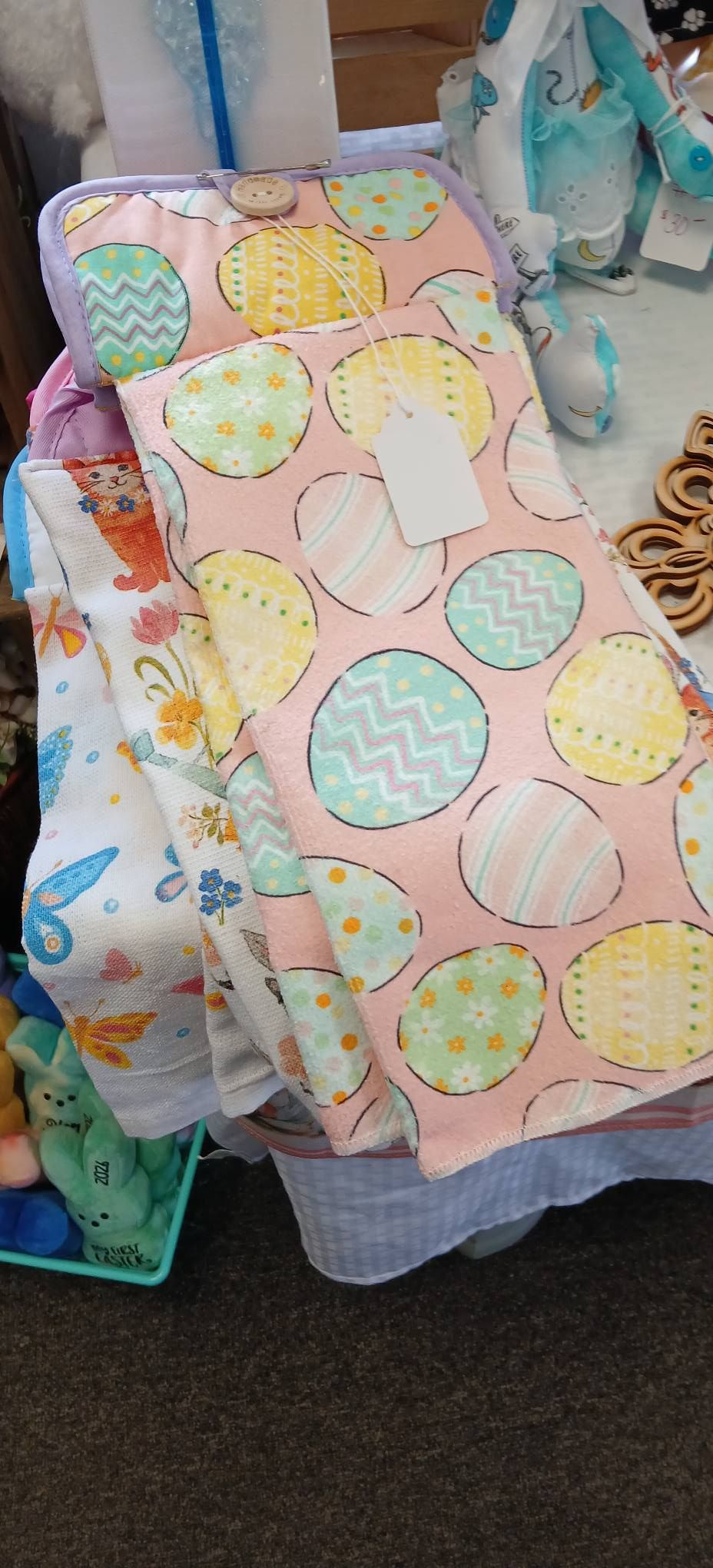 Colorful pastel children’s dress with polka dots hanging among other clothes in a store.