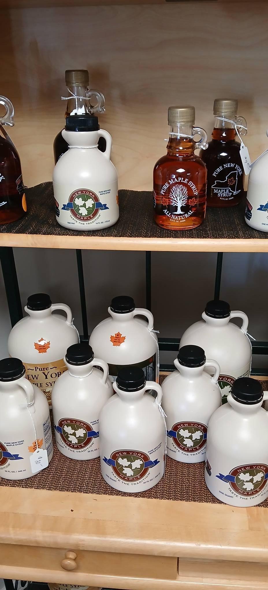 Shelves of small ceramic bottles and glass decanters with decorative labels and stoppers