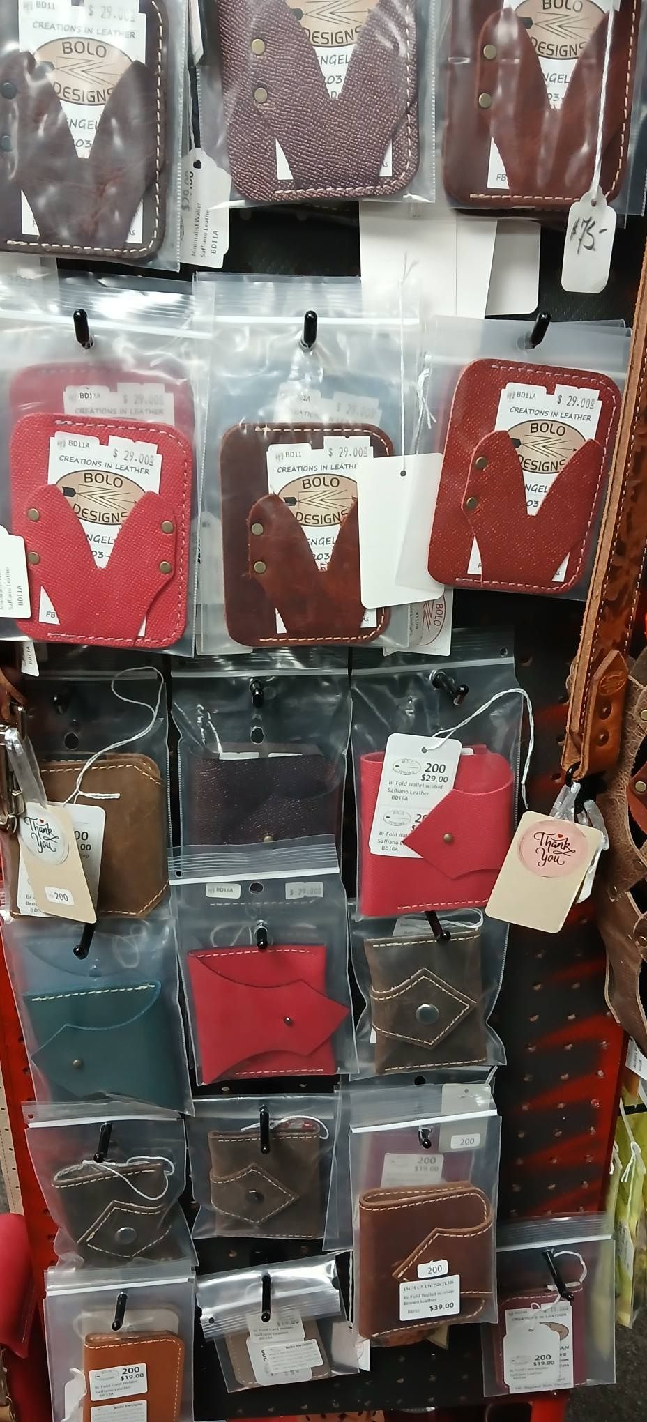 Wall display of packaged red, brown, and black knit gloves with white winter designs