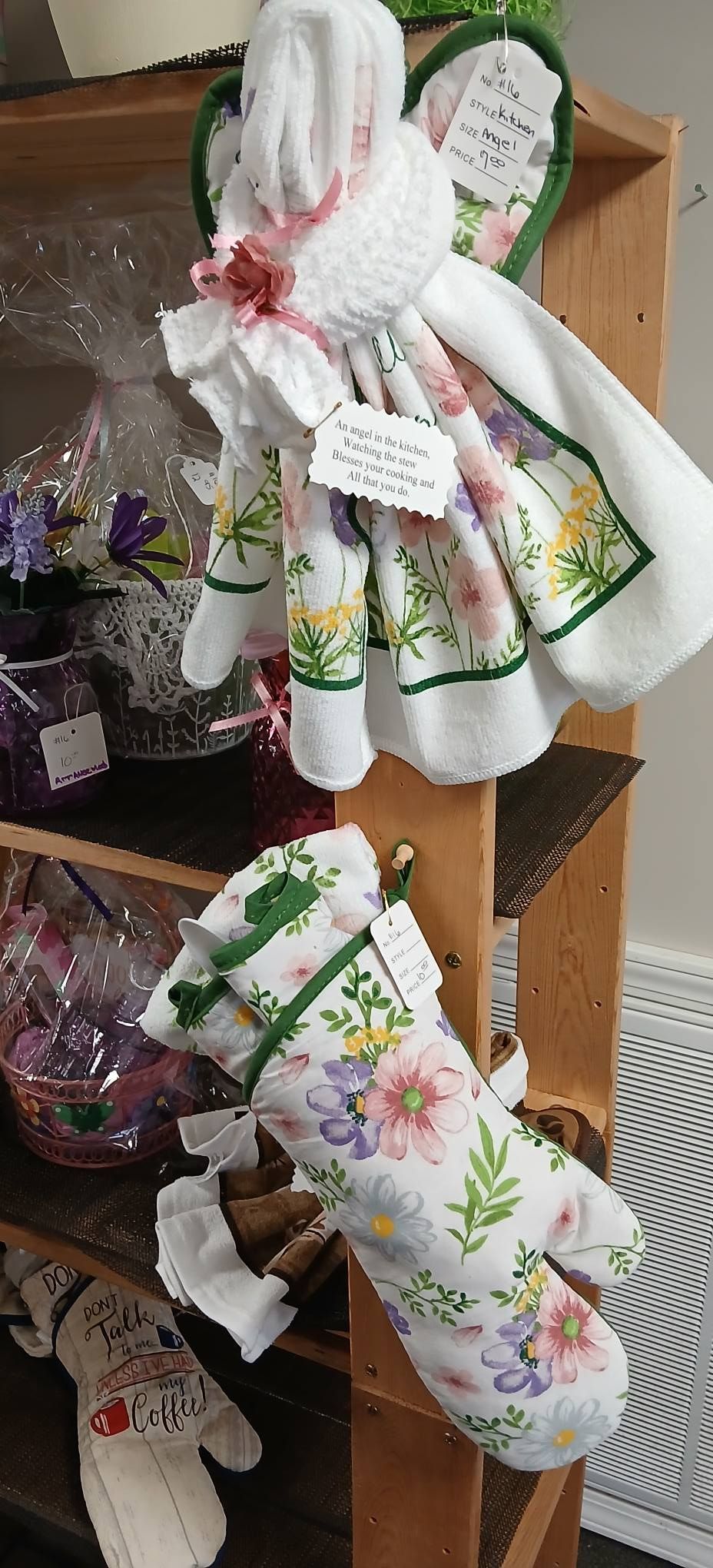 Decorative fabric kitchen towels with floral prints tied with ribbons on a wooden shelf