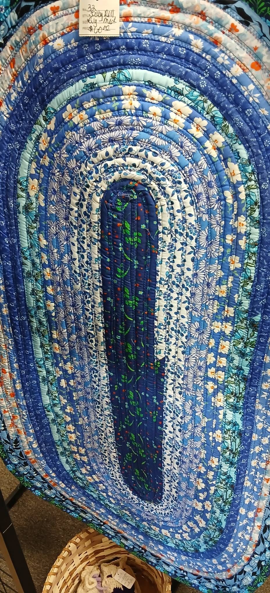 Blue and white mosaic oval with a dark center, framed by a decorative tiled pattern