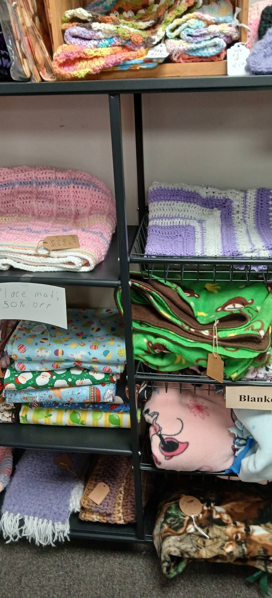 Shelves stacked with neatly folded colorful fabrics and quilts in a store display