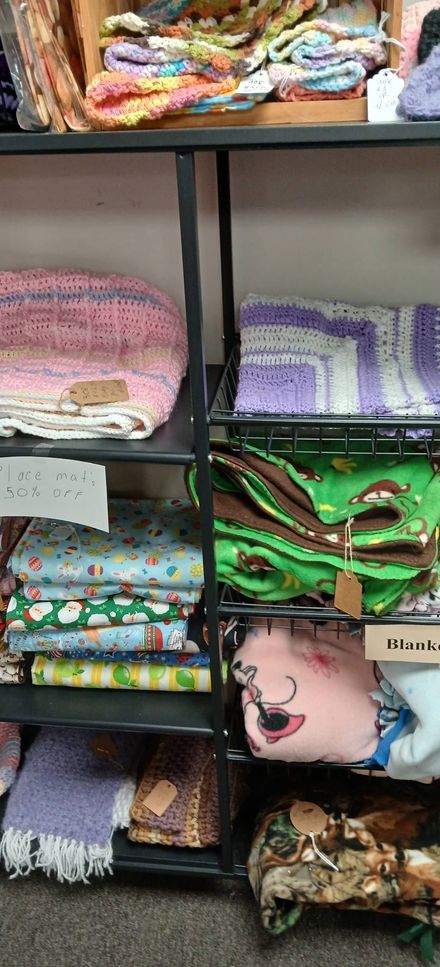 Shelves of folded colorful fabrics and quilts in a shop display