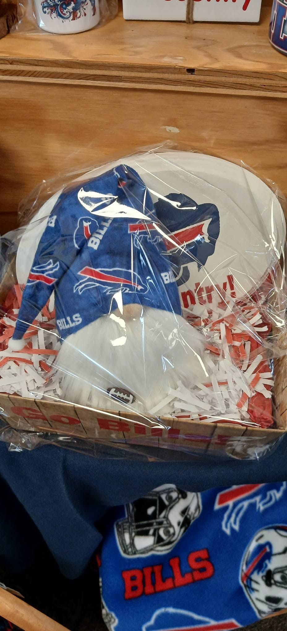 Blue Buffalo Bills shirt with football graphic in a plastic bag on a wooden table