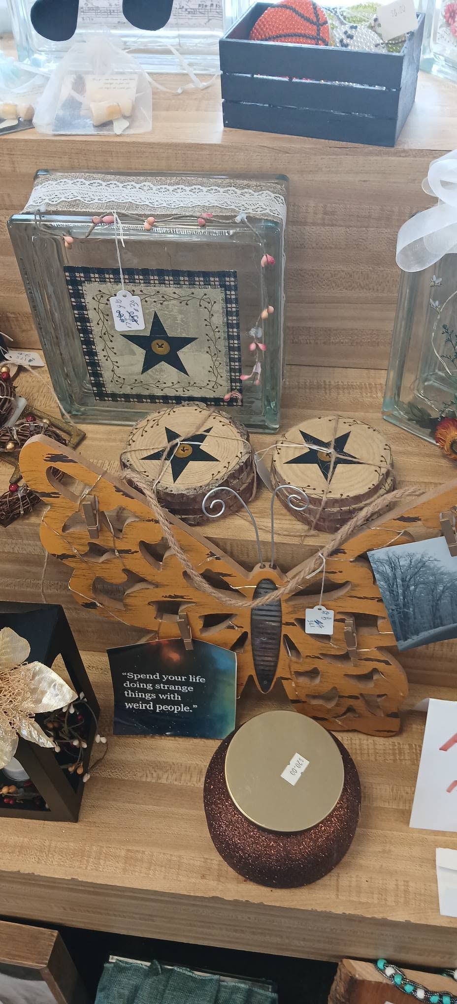 Craft fair display of star-themed holiday ornaments and rustic decorative items on a wooden table