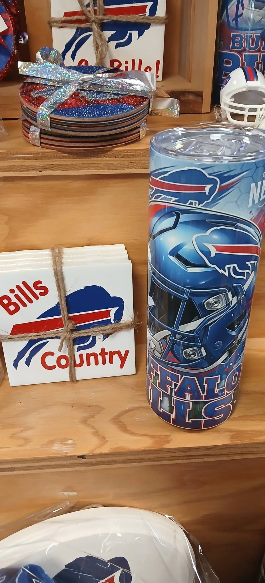 Buffalo Bills-themed tumblers and stacked paper cups on a wooden table