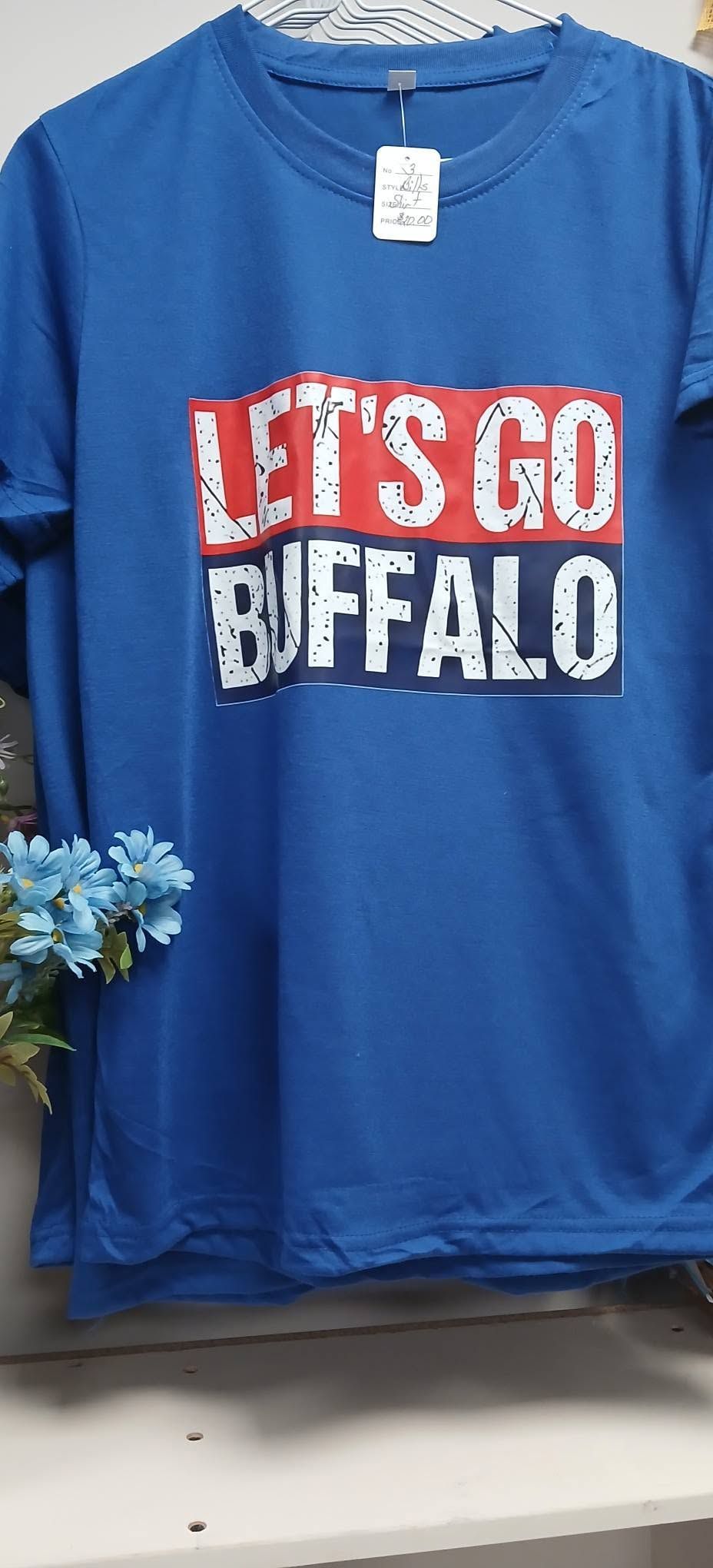 Blue T-shirt with red and white “LET’S GO BUFFALO” text displayed on a hanger.