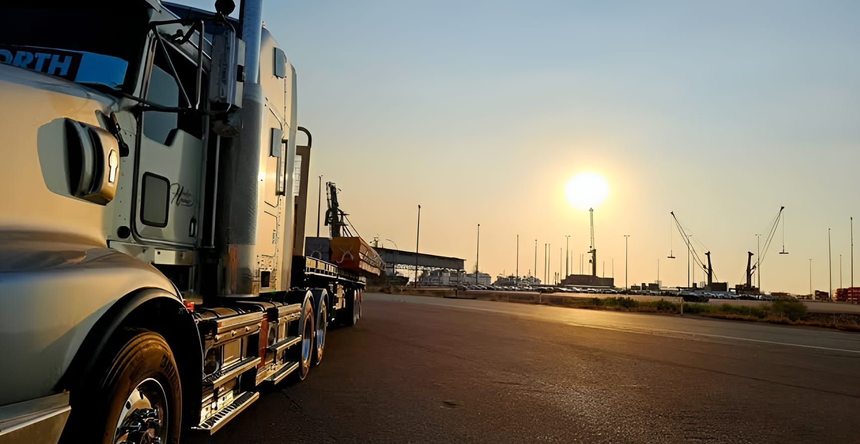 A semi truck is parked on the side of the road at sunset — Harker Haulage In East Arm, NT A semi truck is parked on the side of the road at sunset — Harker Haulage In East Arm, NT