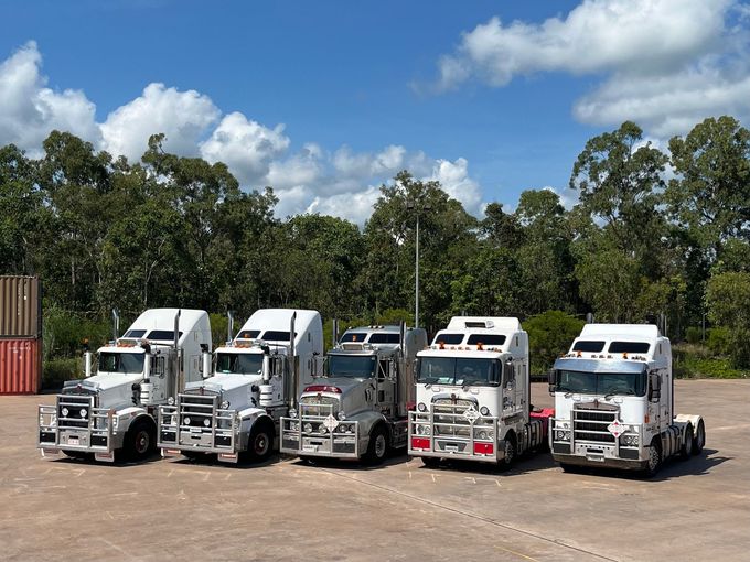 A Row of Semi Trucks Are Parked Next to Each Other on a Dirt Road — Harker Haulage In East Arm, NT A Row of Semi Trucks Are Parked Next to Each Other on a Dirt Road — Harker Haulage In East Arm, NT