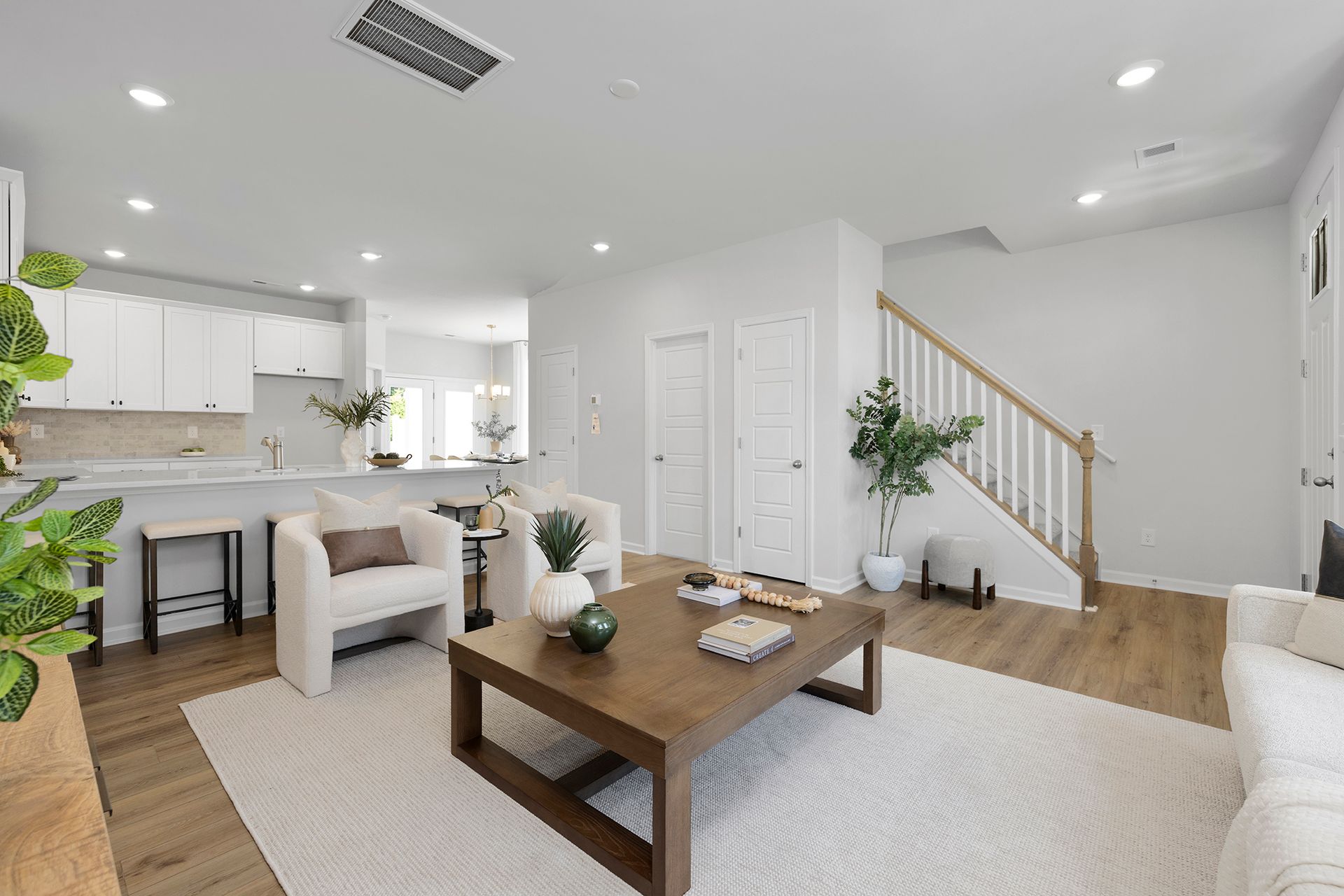 Photo of a great room with white furniture open to the kitchen