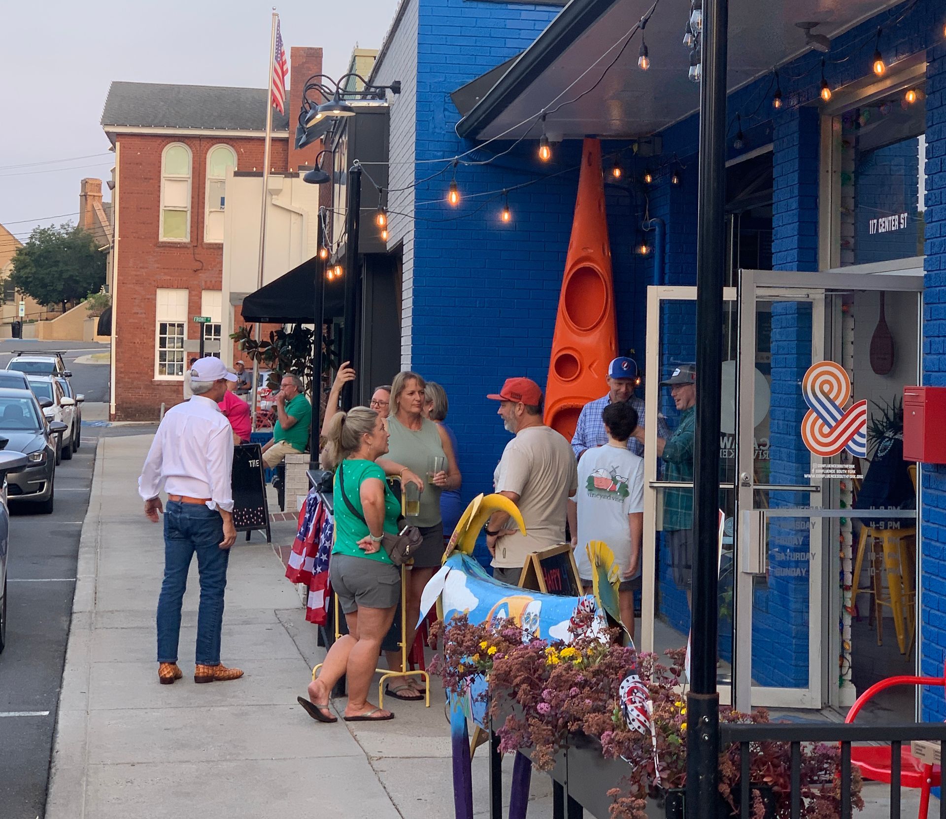 Group of people gathered outside a local business in Cramerton, NC, highlighting community life and small-town charm.