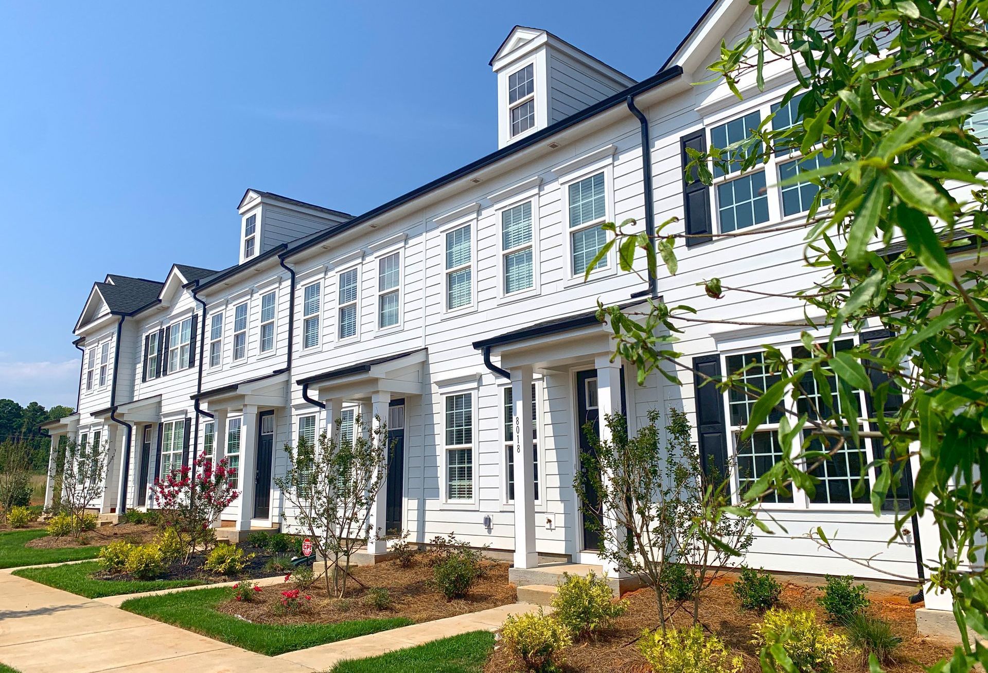 Brookline Homes townhome community showcasing charming exterior and landscaping, perfect for Queen City spring buyers.