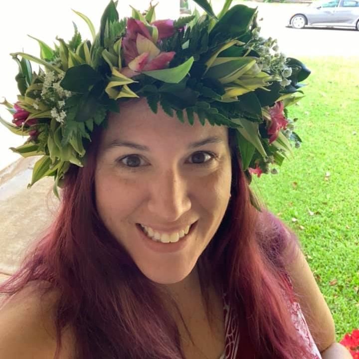 A woman wearing a flower crown is smiling for the camera