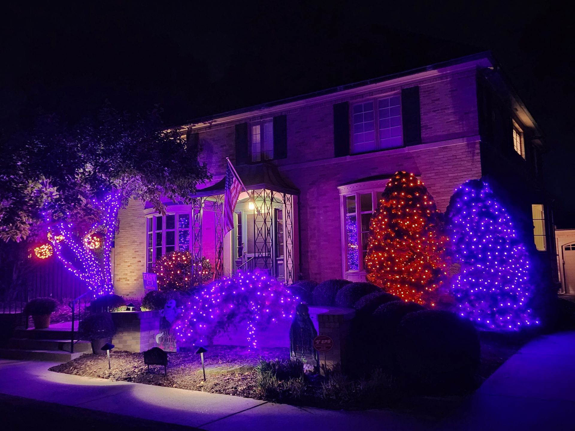 House decorated with purple and red Christmas lights at night