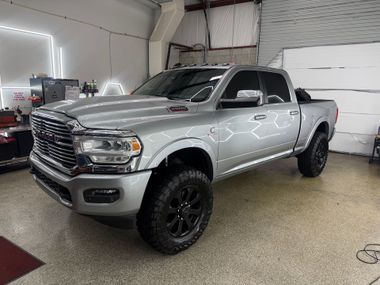 Silver pickup truck in a garage, front three-quarter view with black wheels