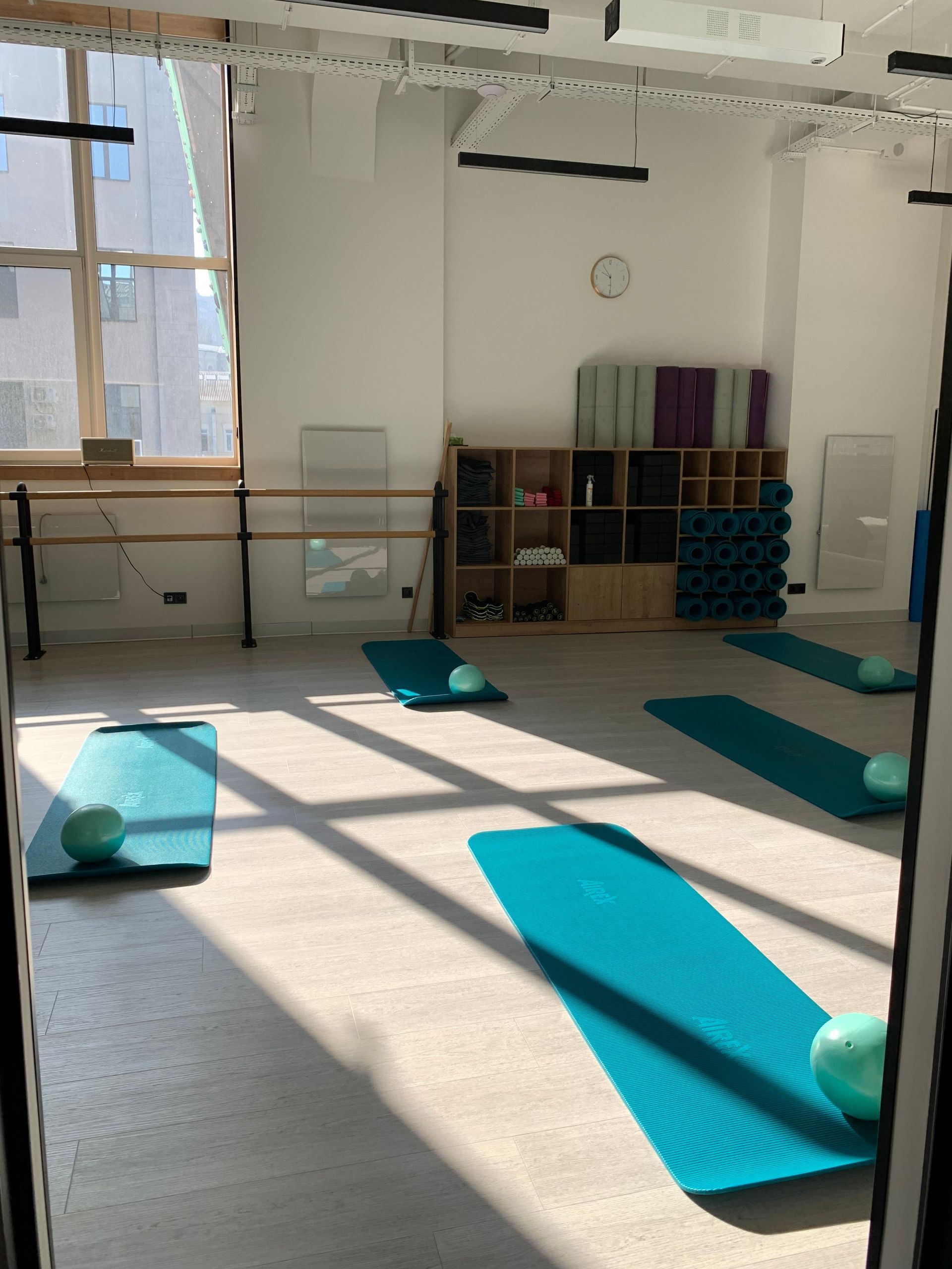 Sunlit movement studio with mats laid out for class