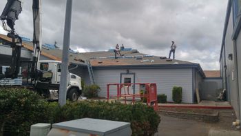 Roofing crew installing a roof on a single-story home