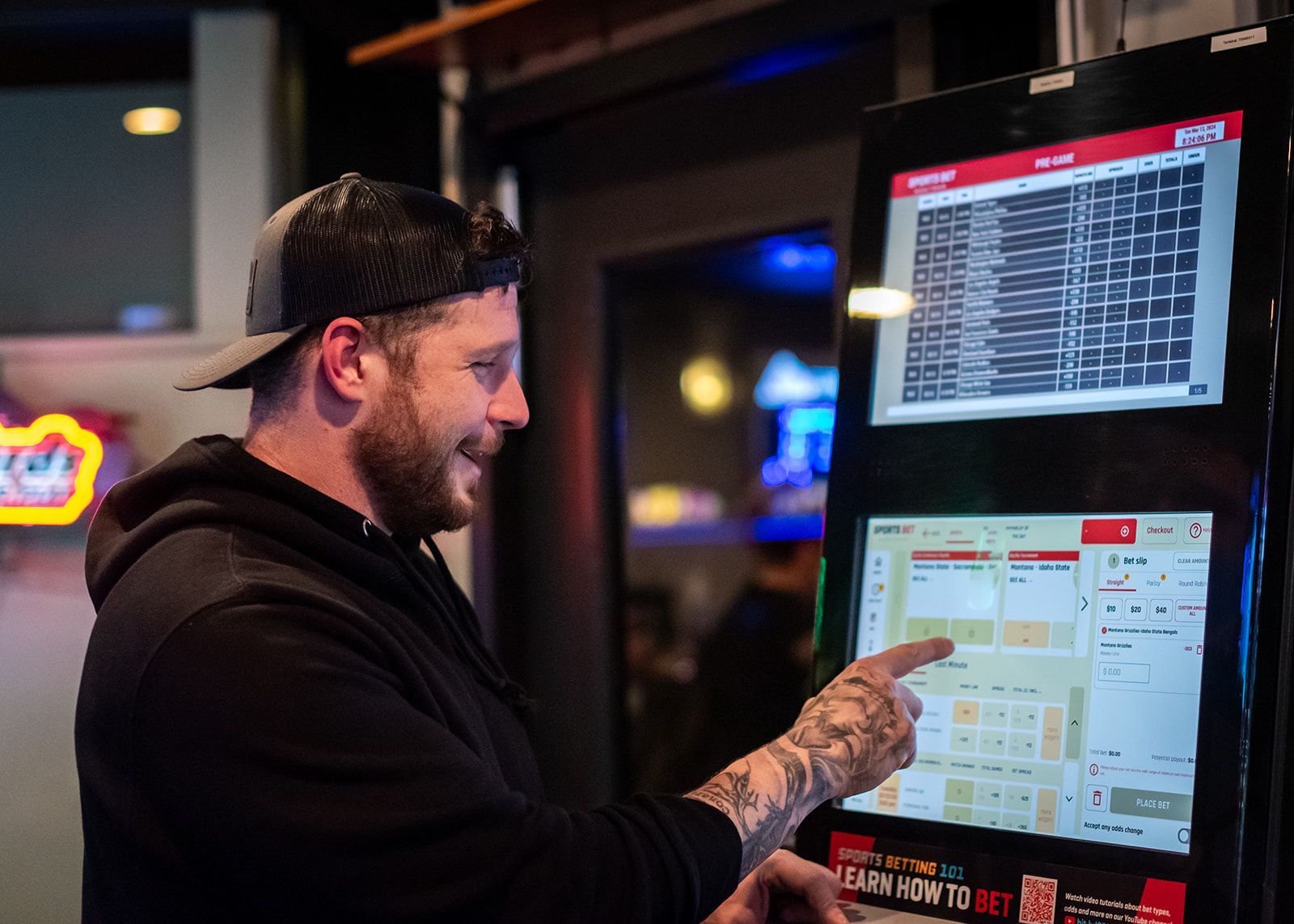 A man is pointing at a screen in a restaurant.