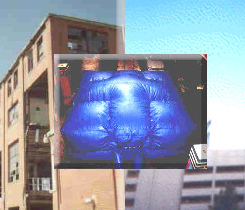 A blue inflatable rescue cushion is superimposed over a composite background of buildings.