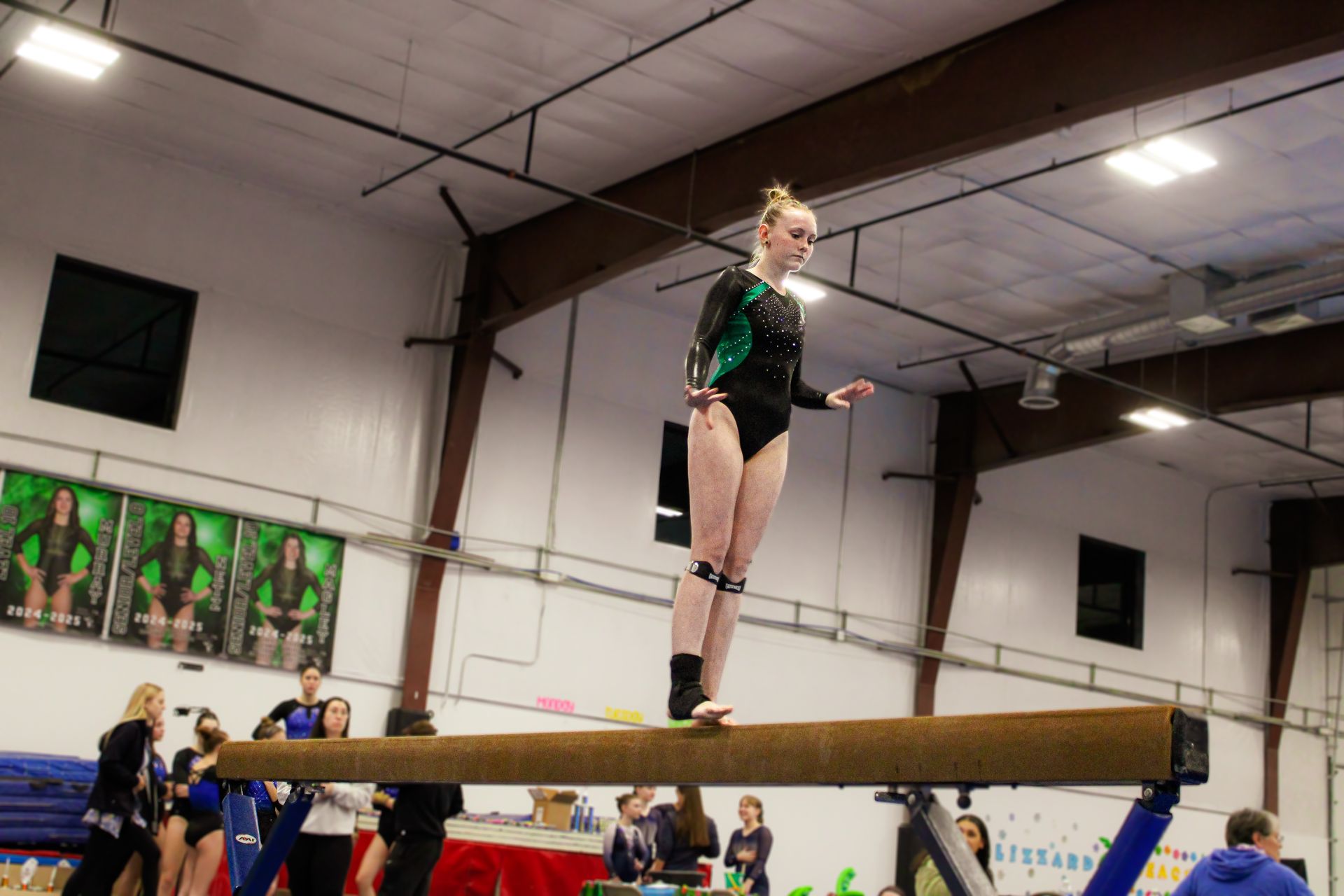 Gymnast balancing on a beam in an indoor gymnasium during practice