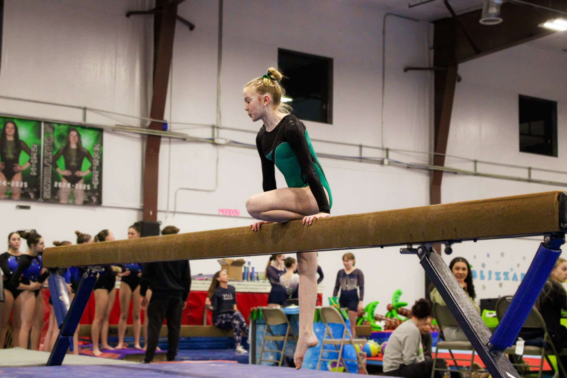 Gymnast balancing on a beam in a gymnasium during practice competition