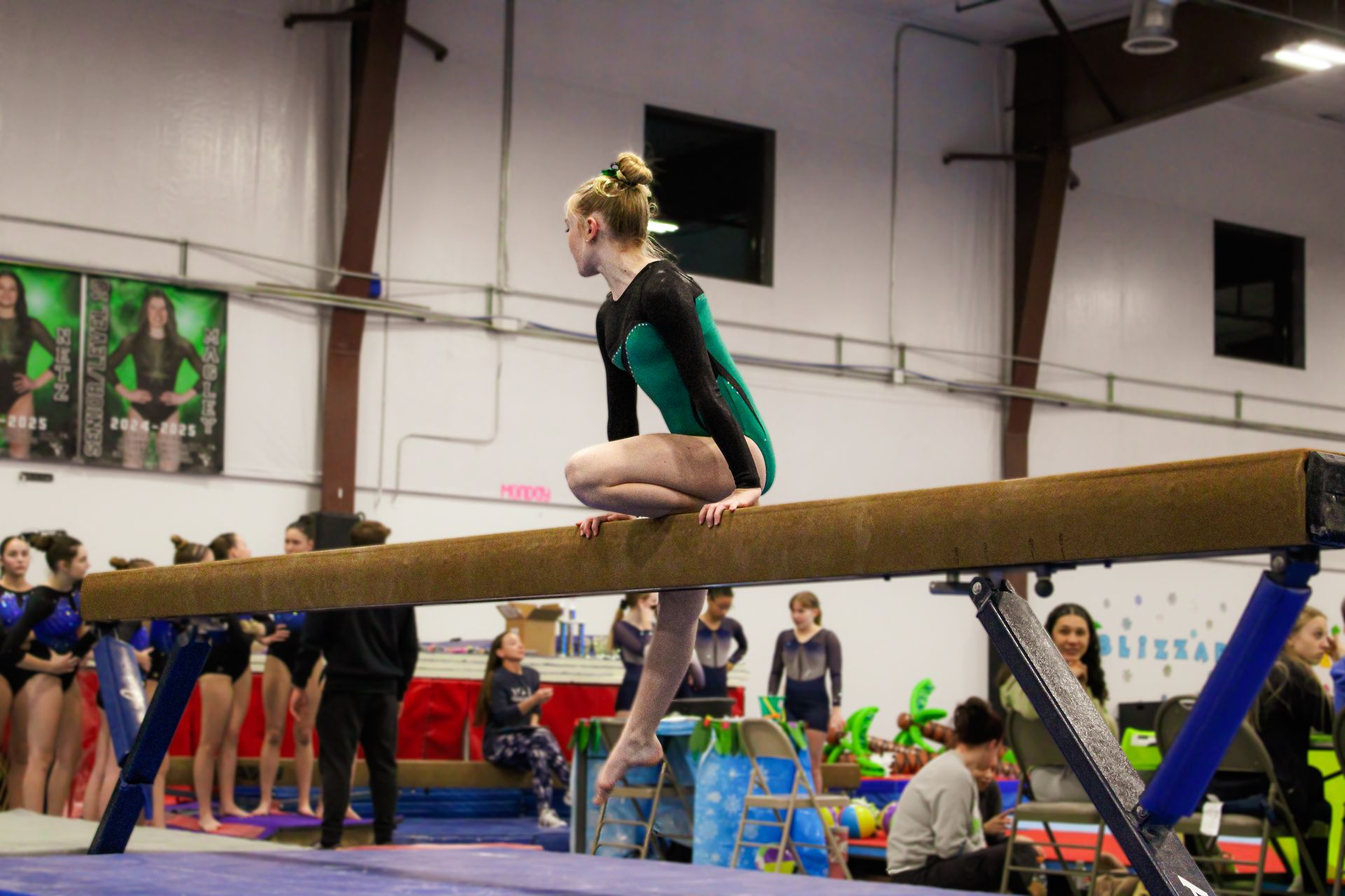Gymnast balancing on a beam during a competition in an indoor gymnasium