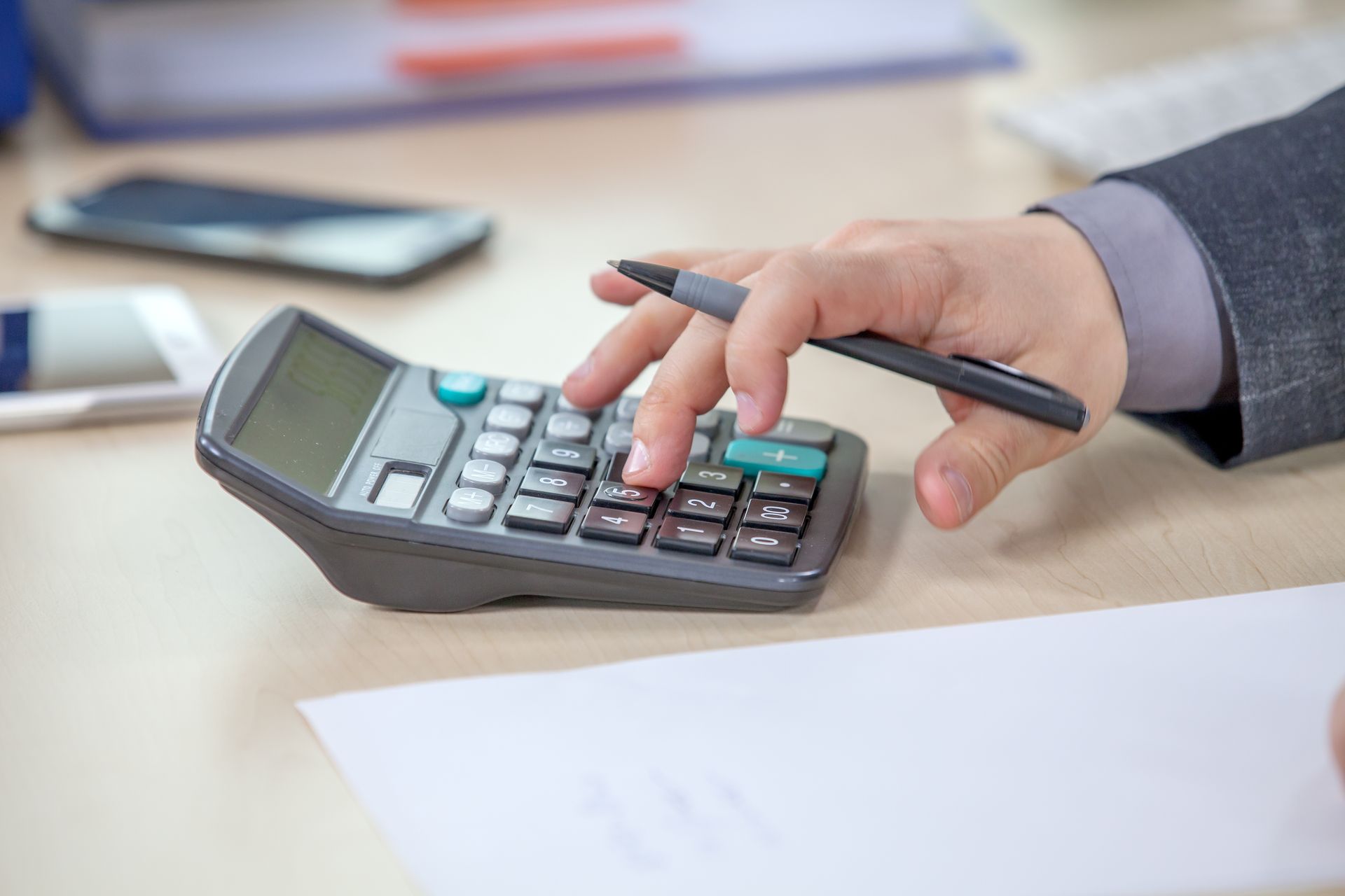 A person is using a calculator with a pen