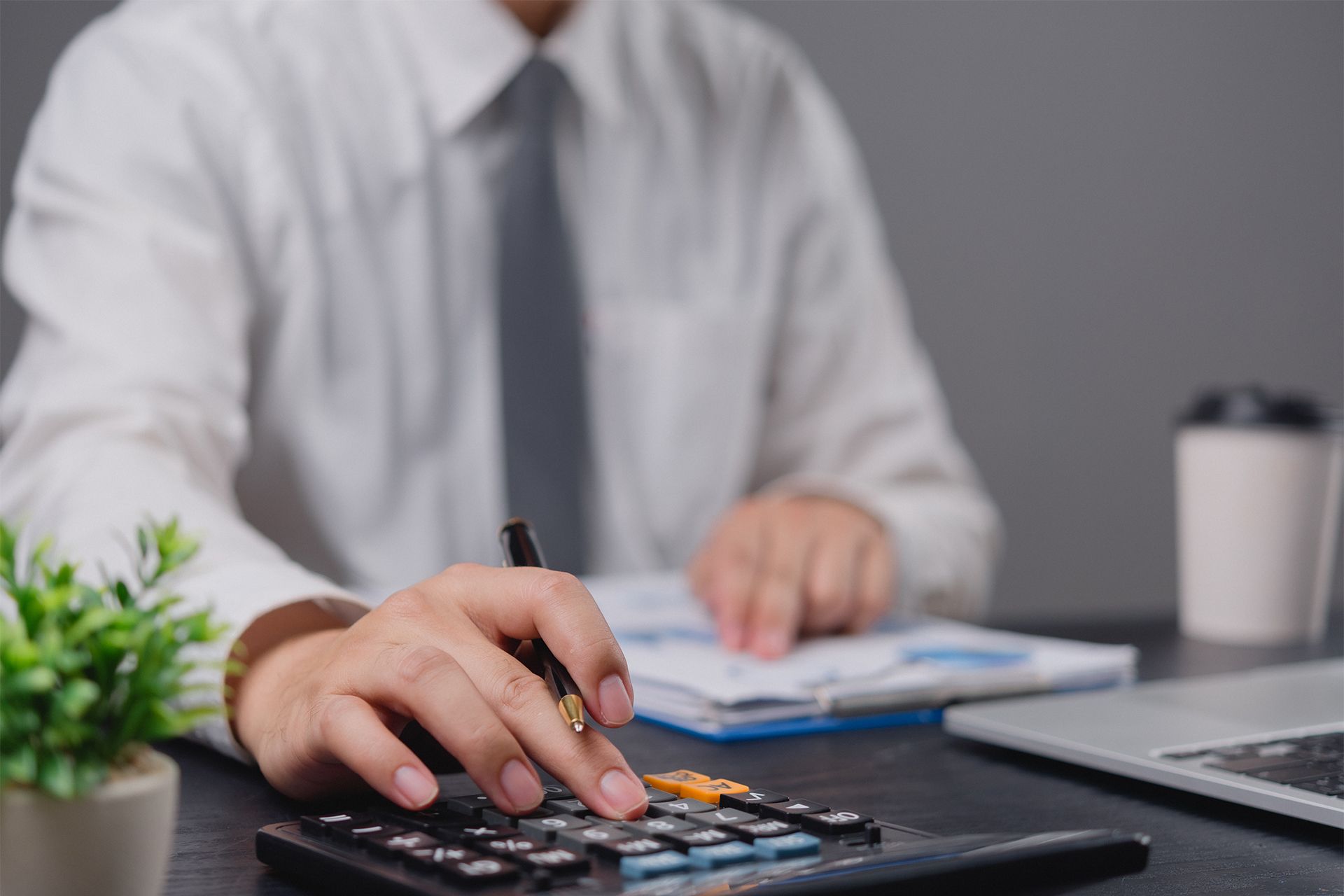 Accountant Sitting at a Desk Using a Calculator