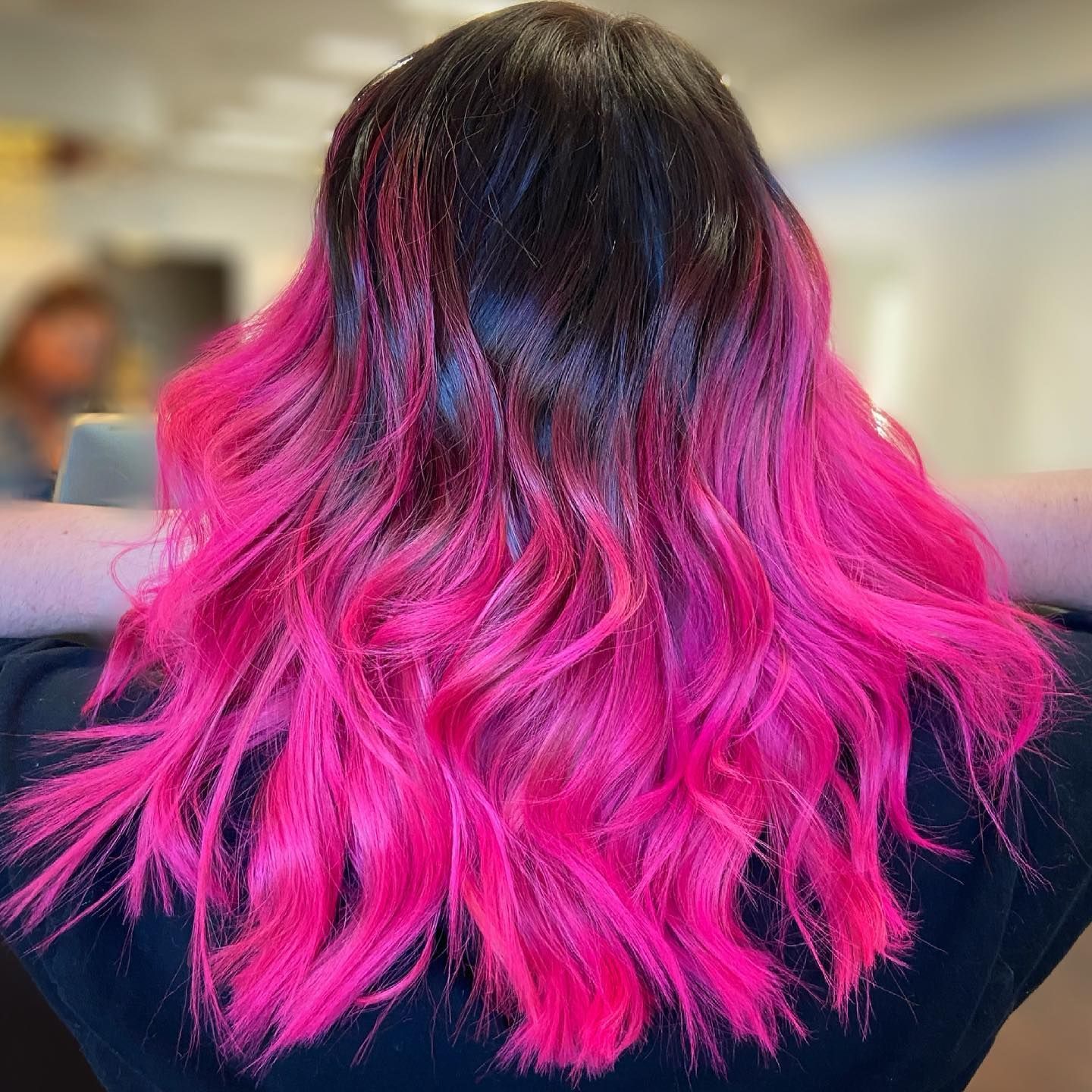 Black hair fading to vibrant pink waves.