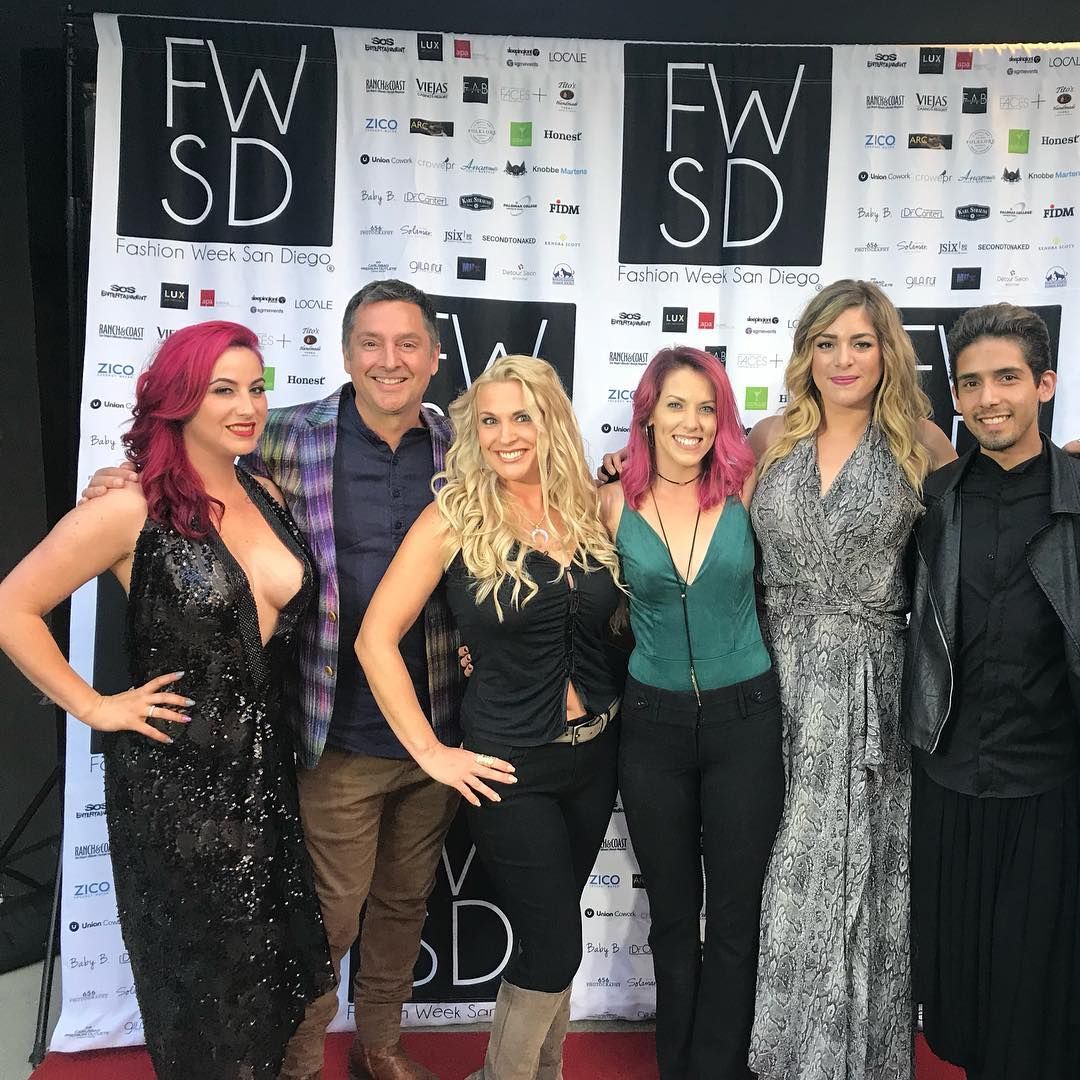Group of six people posing in front of a backdrop with 