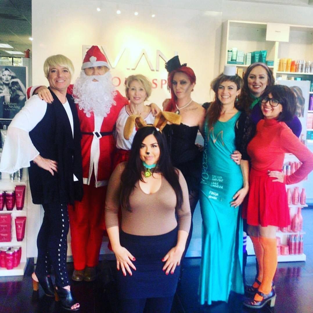 Group of people in costumes, posing inside a salon. Characters include Santa, a mermaid, and Daphne.