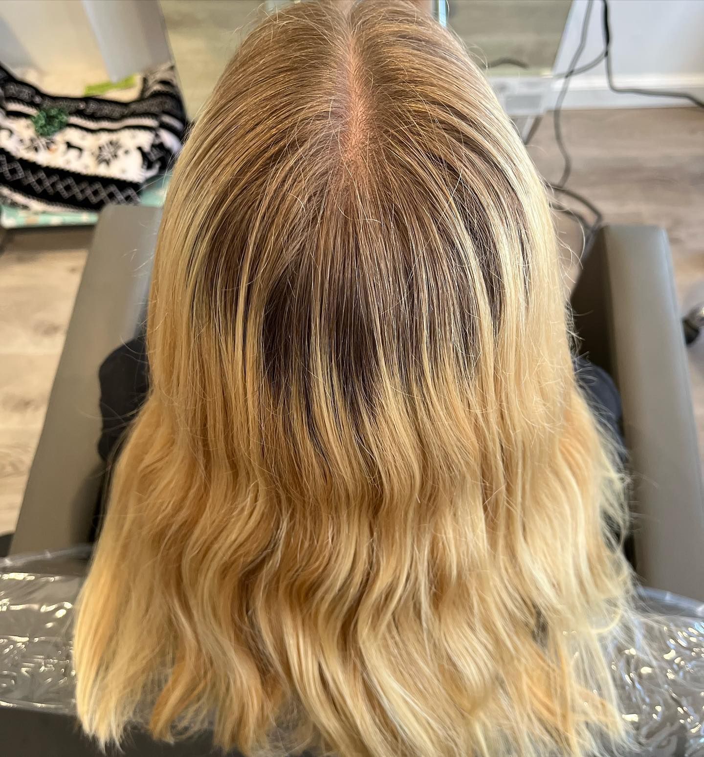 Blonde hair with dark roots, likely undergoing a color treatment at a salon.