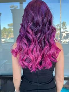 Woman with wavy, purple hair that fades to bright pink.