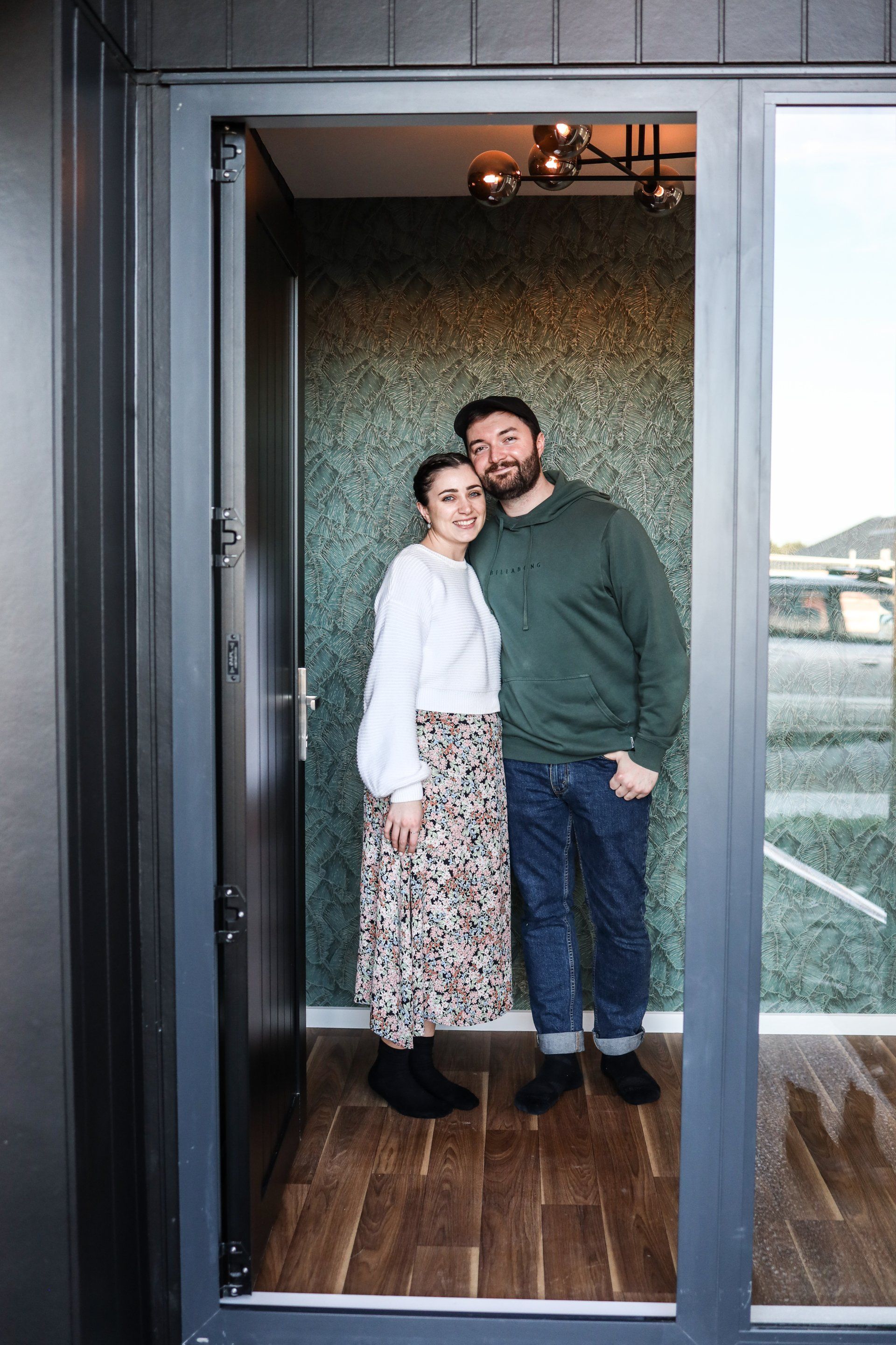 A man and a woman are standing in a doorway.