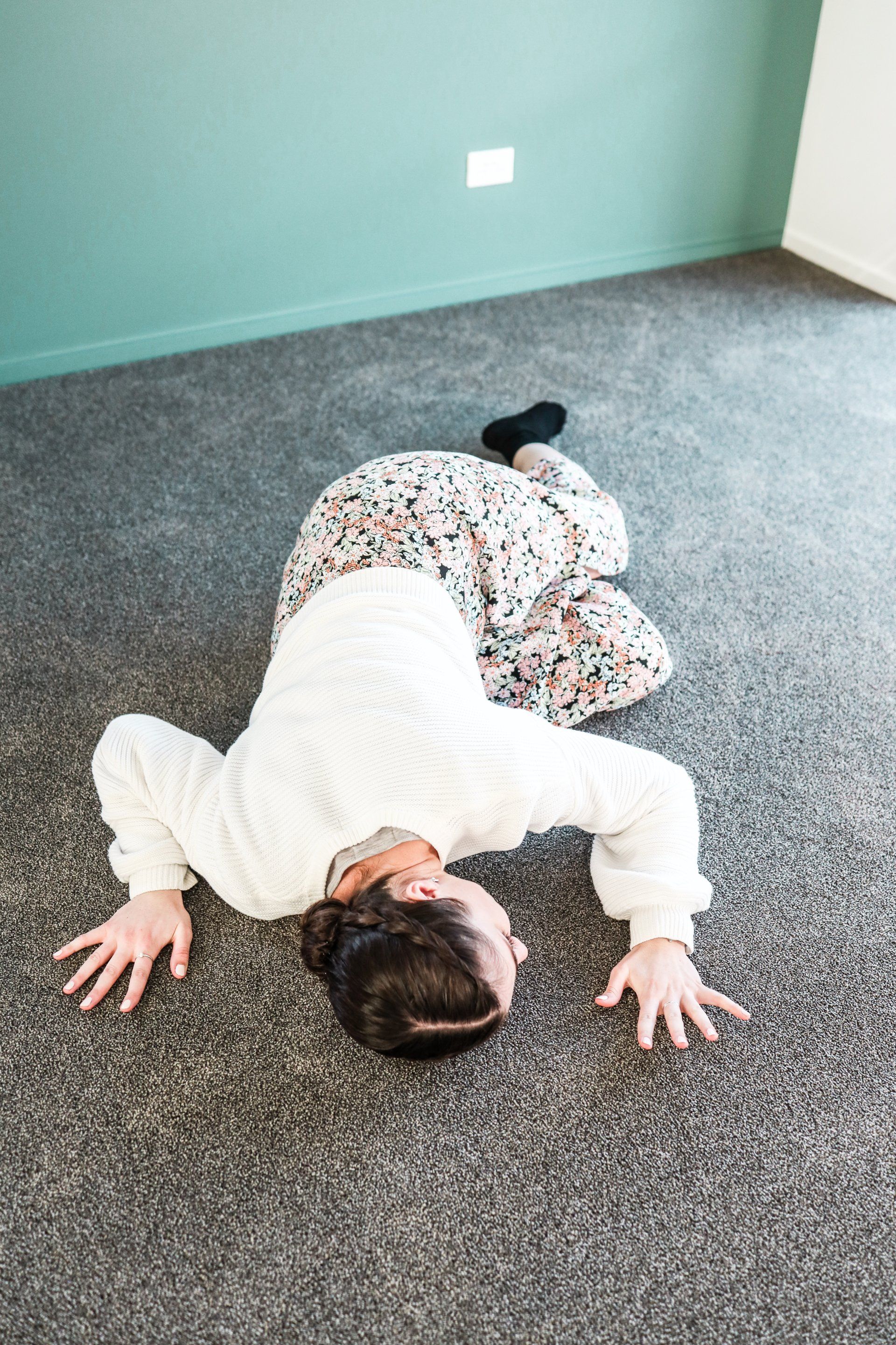 A woman is laying on her back on the floor.