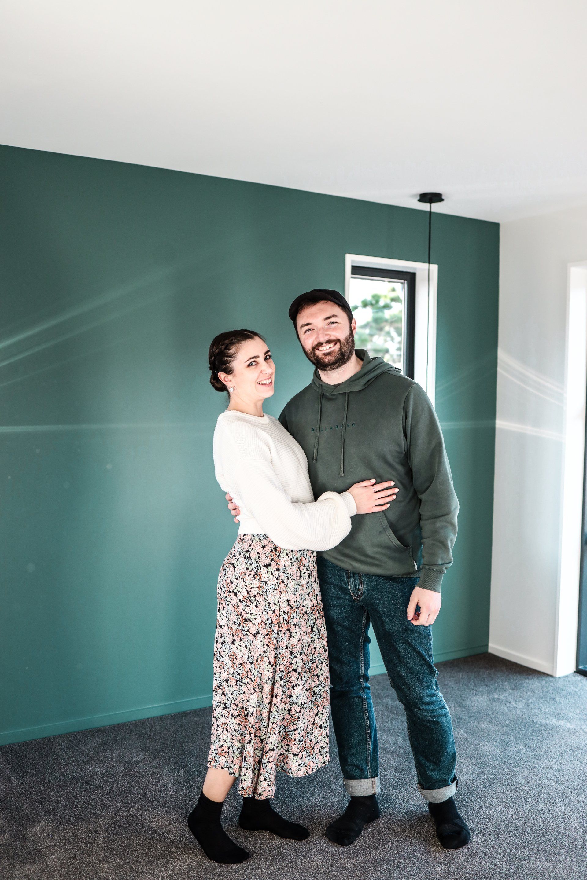 A man and a woman are standing next to each other in an empty room.