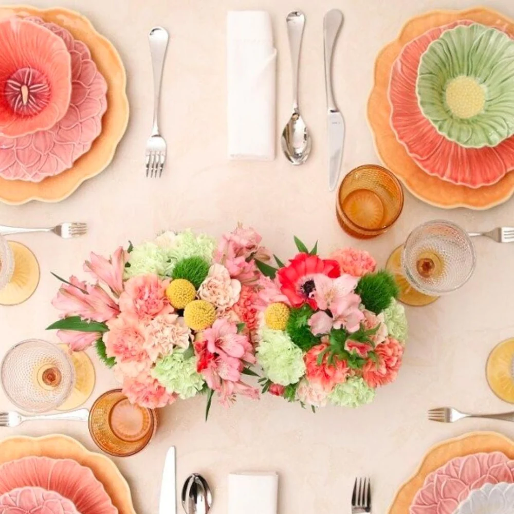 A table set with plates and utensils and a bouquet of flowers