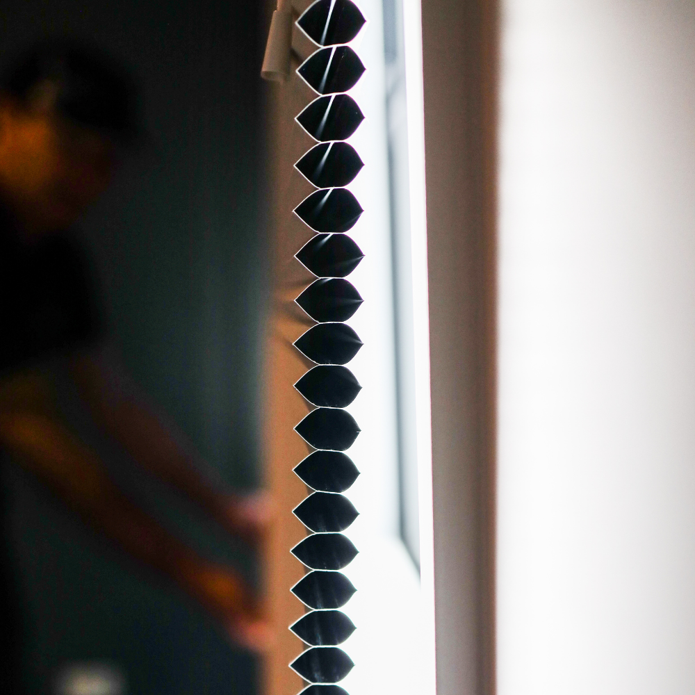 A close up of a black blind on a window