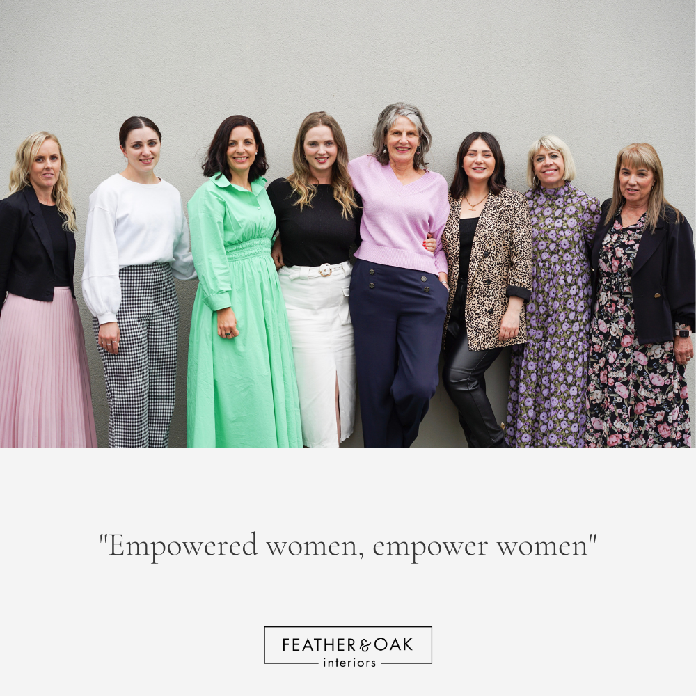 A group of women standing next to each other in front of a wall.
