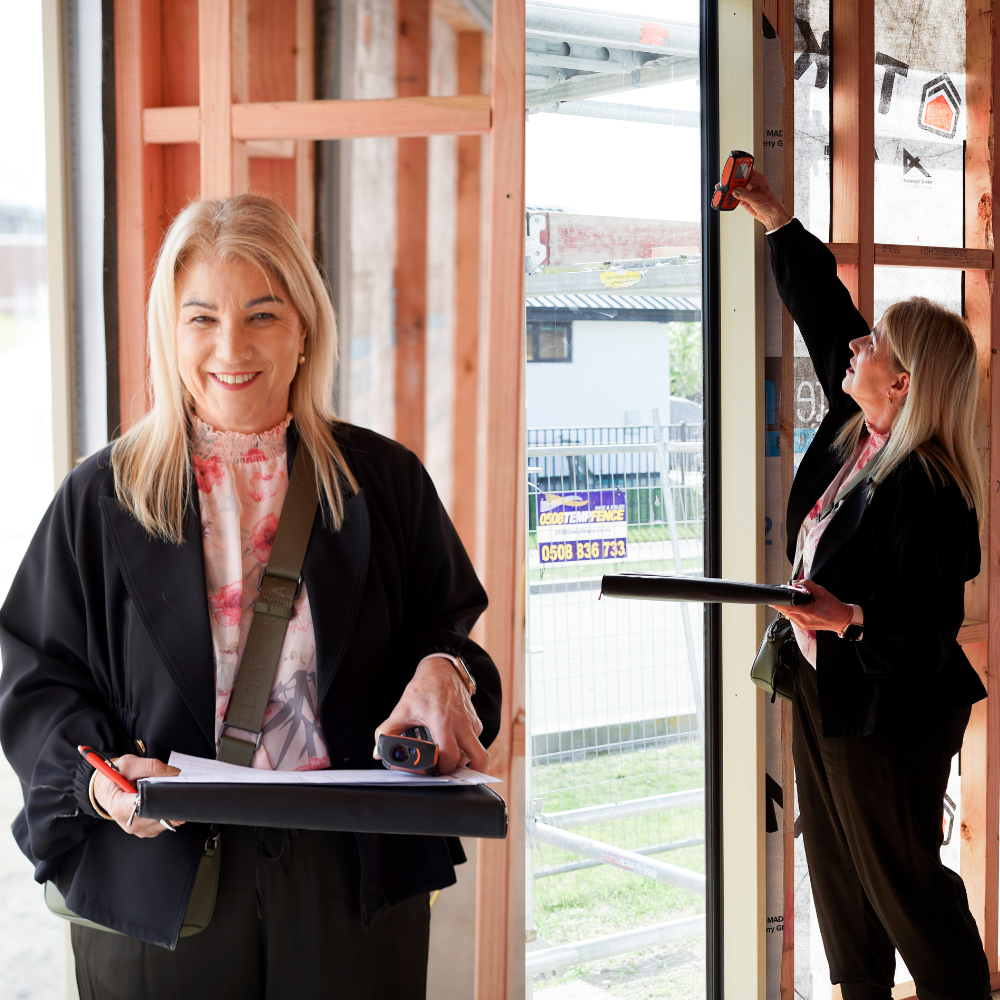 A woman in a black jacket is holding a clipboard