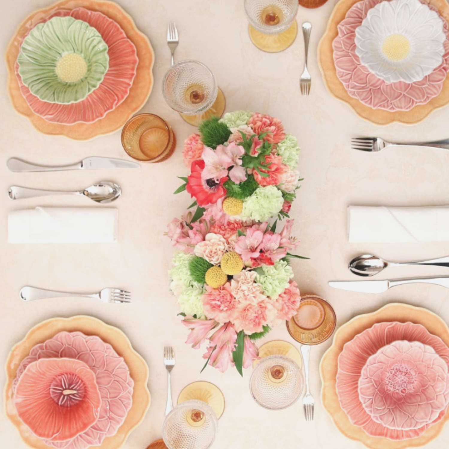A table with plates glasses and flowers on it